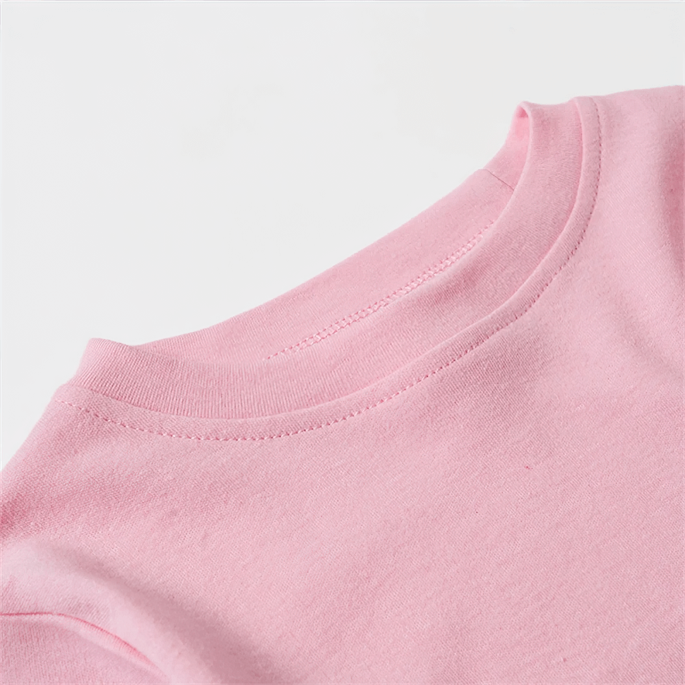 Close-up of pink cotton long-sleeve top with round neckline, showcasing stitching details and soft fabric texture.